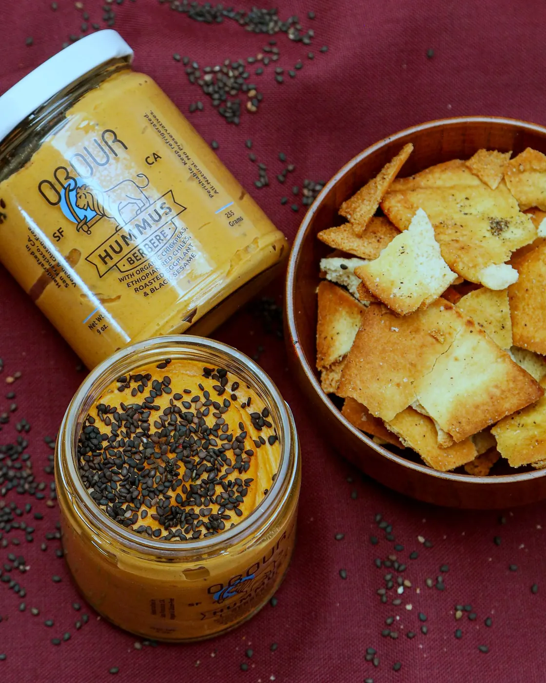 Berbere hummus with black sesame next to a bowl of pita chips